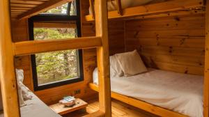 a room with two bunk beds in a log cabin at Loica in Pichilemu