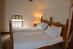 a bedroom with a large bed with white sheets and pillows at Lodge Barns in Fiskerton