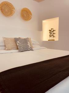 1 dormitorio con 1 cama con sábanas y almohadas blancas en Casa Di Manto Traditional Apartment en Mykonos