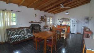 eine Küche und ein Wohnzimmer mit einem Tisch und einem Sofa in der Unterkunft Los Agapantos in Concordia