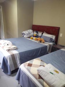 a bedroom with two beds with stuffed animals on them at Hospedaje Encarnación in Encarnación