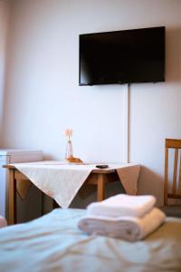 Hotel Dalmacija في ماين: غرفة مع طاولة وتلفزيون على جدار