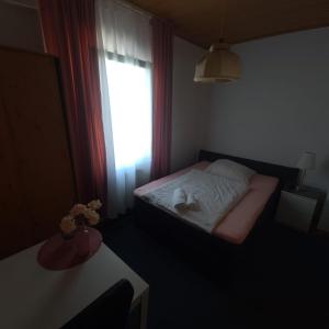 een kleine slaapkamer met een bed en een raam bij Hotel Dalmacija in Mayen