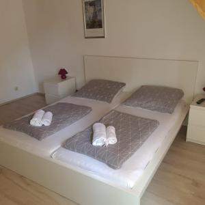 twee bedden in een witte kamer met handdoeken erop bij Hotel Dalmacija in Mayen