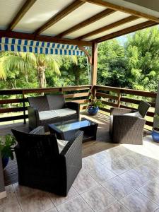 un patio con sillas y una mesa en una terraza en Charmante maison à la croisée des plages, en Le Vauclin