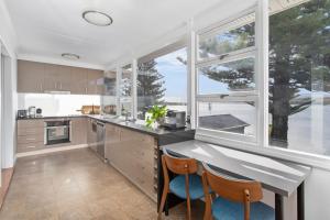 a kitchen with a large window and a table and chairs at The Little Lake House in Primbee