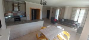een keuken en een woonkamer met een tafel en stoelen bij Ölüdeniz Özel yüzme havuzlu villa 2 in Fethiye