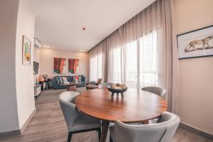uma sala de jantar com uma mesa de madeira e cadeiras em Fully Serviced Apartment at Regatta Living - 3B em Santo Domingo