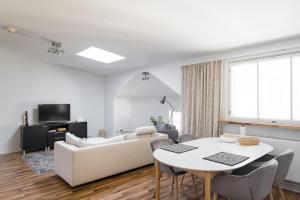 a living room with a white couch and a table at Yellow Tower in Design District Helsinki, 1 bedroom apartment, top floor in Helsinki