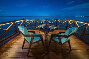 una mesa y dos sillas en la cubierta de un barco en Mia Bacalar Luxury Resort & Spa, en Bacalar