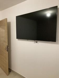 a flat screen tv hanging on a wall at B&B Sainte Marie du Mont (chambres d’hôtes) in Sainte-Marie-du-Mont
