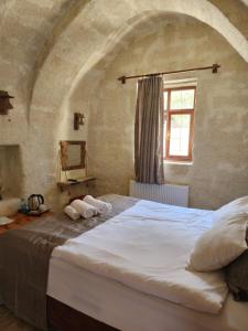 a bedroom with a large bed in a stone wall at Glamada Cave Suites in Urgup