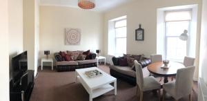 una sala de estar con un sofá y una mesa en Arran Ferry Apartment, en Ardrossan