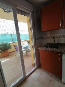 une cuisine avec une porte coulissante en verre menant à une terrasse. dans l'établissement Relax & home, apartamento con terraza y parking, à La Zubia