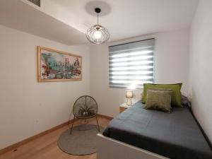 a bedroom with a bed and a window and a chair at Relax & home, apartamento con terraza y parking in La Zubia