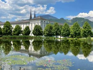 ein Gebäude mit Spiegelung in einem See in der Unterkunft Hotel die Traube in Admont