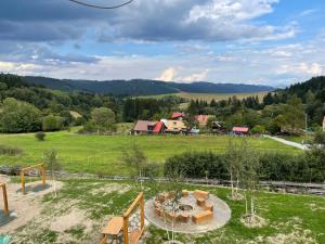 a view of a field with a house in the distance at Drevenice Horné Kysuce in Vysoká nad Kysucou