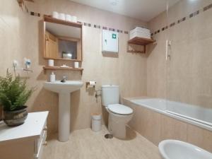 a bathroom with a toilet and a sink and a tub at Relax & home, apartamento con terraza y parking in La Zubia +35 photos