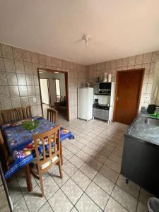 cocina con mesa y cocina con nevera en Apartamento Amplo em Balneário Camboriú, en Balneário Camboriú