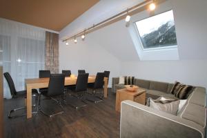 a dining room with a table and chairs and a couch at Relax Apartments in Ischgl