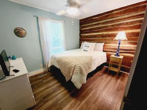 een slaapkamer met een bed en een houten muur bij Beautiful Lakefront Cottage with Boat Dock in Lucas