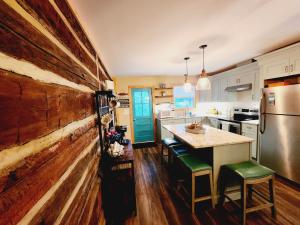 cocina con pared de madera y mesa con sillas verdes en Beautiful Lakefront Cottage with Boat Dock, en Lucas