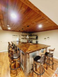 a kitchen with a large wooden bar with chairs at Beautiful Lakefront Cottage with Boat Dock in Lucas