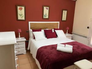1 dormitorio con 1 cama grande y paredes rojas en La Casa De Marta, en Madrigal de la Vera