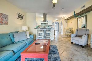 sala de estar con sofá azul y mesa en Coastal Condo with Pool Access - Steps to Beach en Carolina Beach