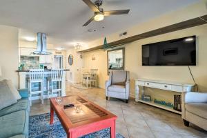 sala de estar con sofá, TV y mesa en Coastal Condo with Pool Access - Steps to Beach en Carolina Beach