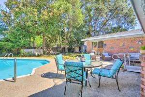 a patio with a table and chairs next to a pool at Family Home with Private Pool and Fenced Yard! in Fort Walton Beach