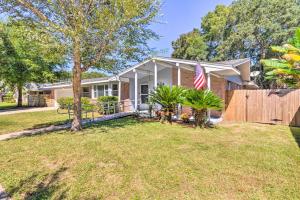 a house with an american flag in a yard at Family Home with Private Pool and Fenced Yard! in Fort Walton Beach