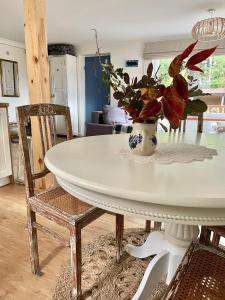 a white dining room table with a vase of flowers on it at Charzykówka Domek na Kaszubach in Charzykowy +13 photos
