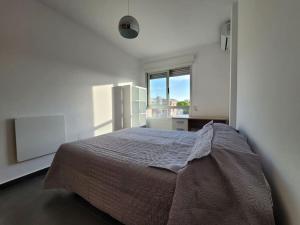 a bedroom with a bed and a large window at Ático dúplex zona Juan de Borbón in Murcia