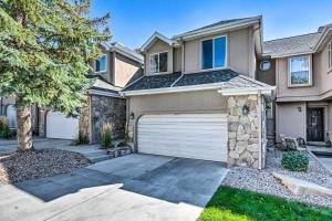 a house with a garage and a tree at Cottonwood Heights Townhome Near Ski Resort! in Cottonwood Heights