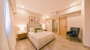 a bedroom with a bed and a chair at Fully Serviced Apartment at Regatta Living - 9F in Santo Domingo +18 photos