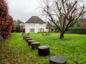 a row of tree stumps in a field with a building at PRIVATE•ASTONISHING•CONTRACTOR•DETACHED•LutonAirport•WI-FI•PARKING•SPACIOUSNESS in Luton