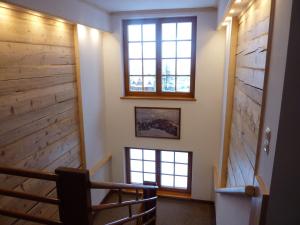 a stairway with three windows and a wall of wood at Willa Litka in Bukowina Tatrzańska