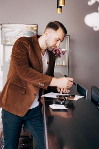 a man standing at a desk in front of a computer at Old Mill Hotel in Klaipėda