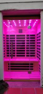 una camera rosa con luci viola all'interno di Vue magnifique, piscine privée chauffée et sauna à 10min de Monaco a Roquebrune-Cap-Martin