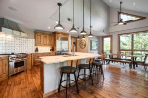 a kitchen with wooden cabinets and a large island with bar stools at Impeccable Lakeside Penthouse in Avon