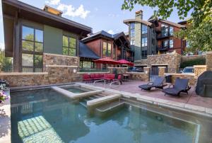 a house with a swimming pool in front of a house at Impeccable Lakeside Penthouse in Avon