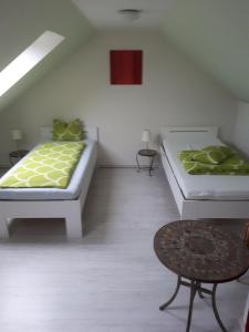 a white room with two beds and a stool at Schleusenwärter Hus in Stralsund