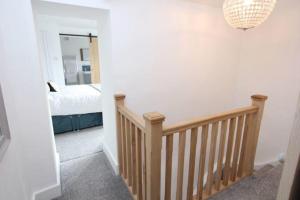a room with a staircase with a bed and a mirror at Beautiful Cottage in Cowbridge in Cowbridge