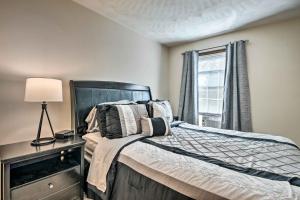 a bedroom with a bed with a lamp and a window at Charming Lewisburg Home with Hot Tub and Games! in Lewisburg