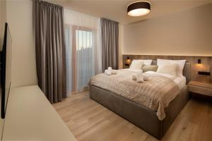 sypialnia z dużym łóżkiem i oknem w obiekcie Apartmán Hillside Panorama w mieście Dolný Kubín