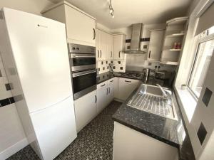 a kitchen with a white refrigerator and a sink at Poplar House in Cleethorpes