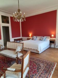 sypialnia z łóżkiem i czerwoną ścianą w obiekcie Maison Zola w mieście Saint-Amand-Montrond