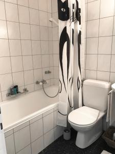 ein Bad mit einem WC und einem Duschvorhang in der Unterkunft Bijou Appartment in Zollikofen