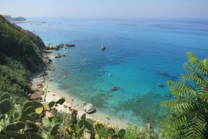 - une vue sur la plage avec des gens dans l'eau dans l'établissement Il Limoneto 3, casa vacanze Parghelia-Tropea, à Parghelia